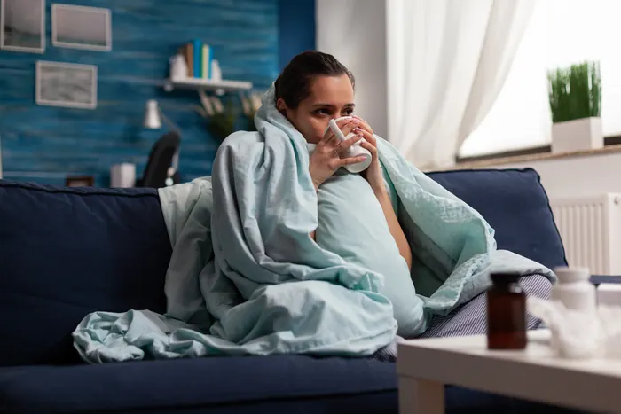 Frau mit Tee auf dem Sofa